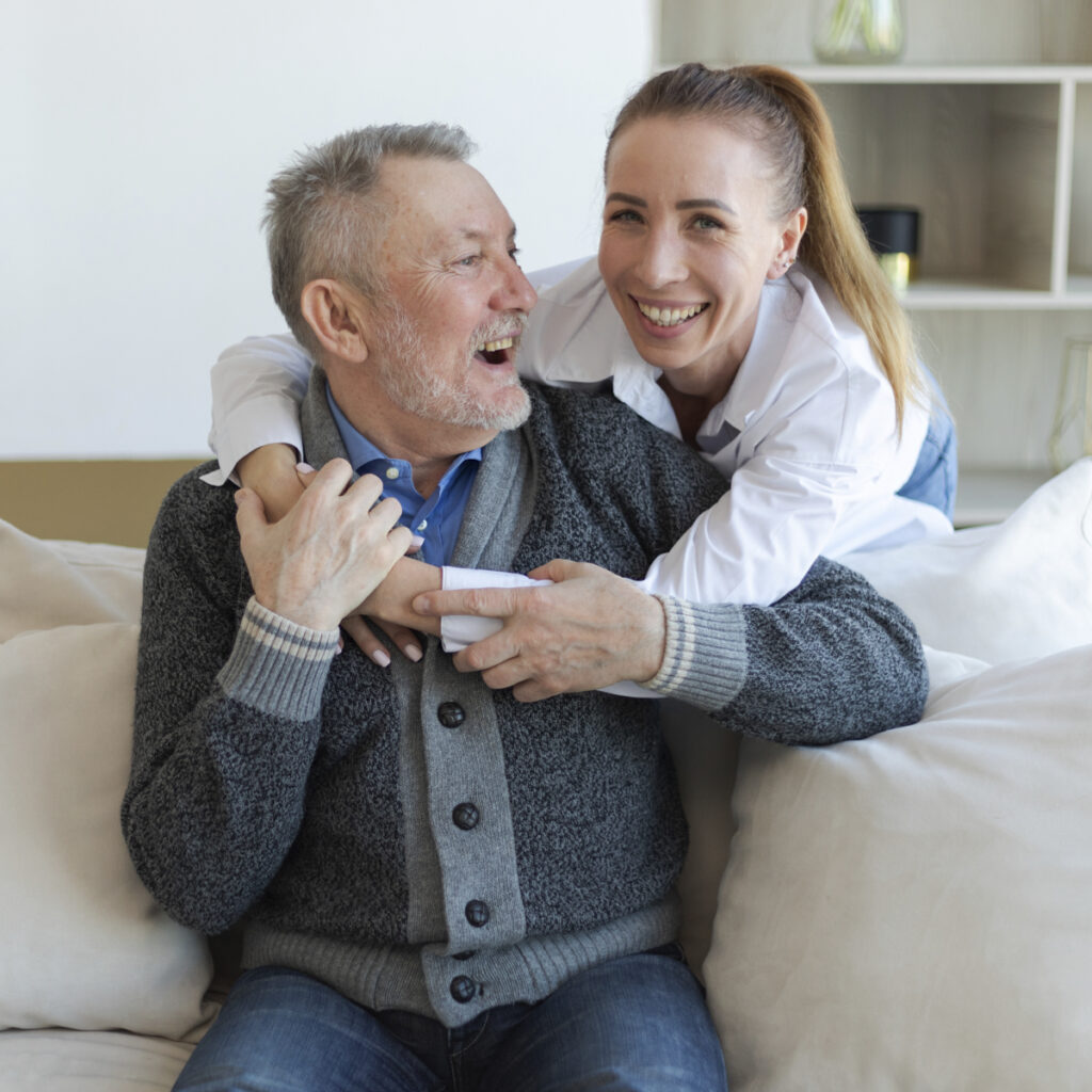 An older man laughing with his adult daughter
