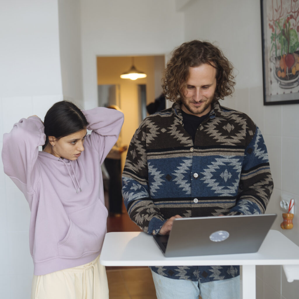 A child working on a laptop with an adult beside them